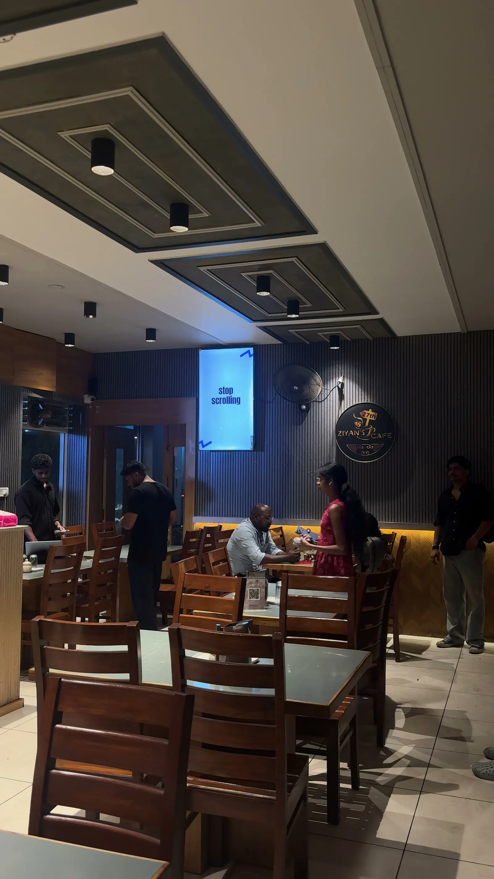 A café dining room with an AdVerse screen on the wall, showing your creative
